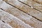 Macro abstract view of an outdoor wooden cedar deck floor with light frosty snow texture