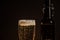 Macro beer bottle and a glass of beer on a dark