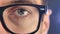 Macro blue eye of man in eyeglasses. Close up eye of businessman or student in glasses