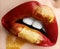 Macro and close-up creative make-up theme: Beautiful plump female lips with red and gold paint, wet effect on the lips