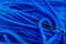 Macro close-up of needle threaded with blue thread.