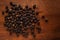 Macro close-up of Organic Black pepper Piper nigrum on wooden top background. Pile of Indian Aromatic Spice.