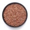 Macro Close up of  Organic Brown flaxseeds Linum usitatissimum or linseed on a black ceramic bowl ,