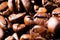 Macro close up of pile of roasted brown coffee beans in natural sunlight showing details of surface