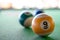 Macro close up shot of a nine ball billiard with some blurry billiard ball in the background