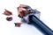 Macro closeup of sharpening a pencil with a grey metal pencil sharpener with wooden swirl shavings on white background