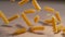 MACRO: Delicious fusilli pasta is scattered across a wooden kitchen counter.