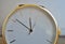 Macro detail of a luxurious golden wrist watch with a white dial on the wooden background as a symbol of and expensive timepiece