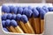 Macro detail of safety match sticks with blue heads in the paper match box (matchbox) in shape of typical cigarette box