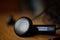 Macro detail of a silver and black perforated headphones (ear-buds) with cables