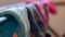 Macro detail of woven ankle sock close up, drying on a laundry rack, with blurred background of other socks, mismatched. Depicting