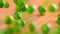 MACRO, DOF: Raw homegrown green peas bouncing off the wooden kitchen table.