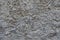 Macro of dusty wall with coarse gray roughcast finish