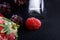 Macro frozen raspberry, blackberry, strawberries mint leaves, pieces of ice on a black shale board, frozen fruit, set