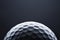 Macro golf ball on dark blue background, space for text.