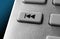 Macro Of A Grey Skip Backward Button On Chrome Remote Control For A Hifi Stereo Audio System