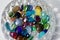 Macro image of colorful dragon tears glass stones surrounding a small crystal bowl