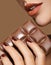 Macro image of female hand with brown nails and bar of chocolate