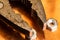 A macro image of the jaws of a rusty well used pair of pliers with several small steel nuts resting on a used and oxidized copper