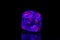 Macro mineral stone ruby under ultraviolet light on a black background