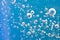 Macro Oxygen bubbles in water on blue background