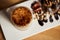 Macro photo of cup of Hot latte with baked caramel crust and sweet roll with banana and strawberry on the wooden table in coffe-