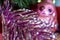 Macro photo of a detail of a violet tinsel with a Christmas toy bird