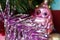 Macro photo of a detail of a violet tinsel with a Christmas toy bird