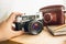 Macro photo of retro manual camera and leather case on table