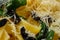 Macro photo with shallow depth of field of pasta with parmesan and chopped olives