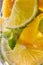 Macro photo of sliced lemon and lime with a leaf of mint and bubbles in glass. Cool drink mojito