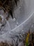 Macro photography of a white feather of a swan with water drops. The drop acts like a magnifying glass and reveals the fine hairs