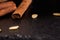 Macro picture of cinnamon sticks and seeds on the black background. Organic cinnamon for healthy beverages. Copy space.