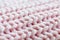 Macro of pink knitted wool pattern, soft focus. Close-up of a fragment of knitted warm sweater. Thick pink wool yarn. Diagonal