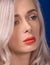 Macro of Platinum Blonde Hair Woman With Blue Eyes and Augmented Lips, Painted With Coral Lipstick, Looking from Profile