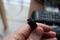 A macro portrait of someone holding a usb c cable in his hands. Ready to charge a phone or other device. Or connect with a