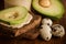 macro of quail eggs, sliced avocado on rye bread, and tahini jar