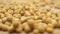 Macro shallow focus pan shot of scattered mustard seeds on wooden table