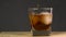 Macro shooting. Bartender is putting crystal ice cubes in a glass while preparing an alcoholic cocktail to customers at the bar on