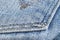 Macro shot Blue jeans pocket fabric texture background with brown stitching. Denim jeans texture. Closeup texture and pattern of