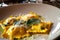 Macro shot of colorful ravioli stuffed with pumpkin and served with sage butter sauce and Parmesan cheese shavings