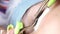 Macro shot of the eyelash extension procedure, the master glues the eyelash with tweezers