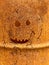 A macro shot of a face cut out on the side of a burn barrel.