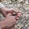 Macro shot of hands of man holding metallic lighter and rope or cord just in moment of setting on fire