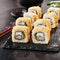 Macro shot of hot crispy ebi tempura maki sushi rolls with cream cheese, king prawn, chuka kelp salad and nori. Deep fried uramaki
