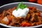 Macro shot of a hot and spicy goulash with chunks of tender beef and vegetables, simmered to perfection