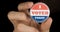 Macro shot of I Voted Today button in holding in hands
