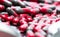 Macro shot of red and grey capsule pills on drug tray