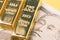 Macro shot of shiny bullion ingot gold bar on Japanese banknote using as wealth investment or savings in financial crisis