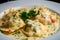 Macro shot of a single ravioli pasta stuffed with lobster and shrimp in a creamy sauce garnished with parsley
